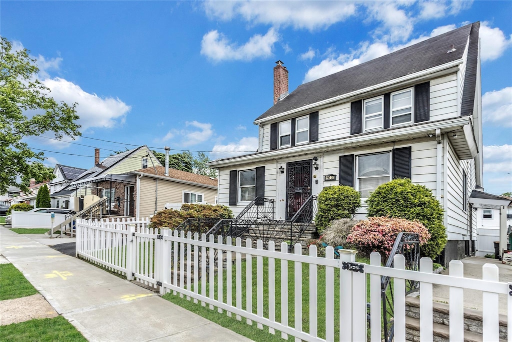 190-30 103rd Ave, Hollis, NY 11423 - view of front of property with a fenced front yard and a chimney