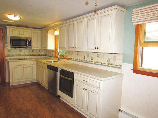 7 Holiday St, Pawling, NY 12564 - kitchen featuring appliances with stainless steel finishes, a sink, light countertops, dark wood finished floors, and decorative backsplash