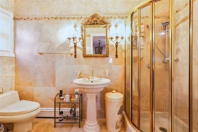 429 E Park Ave, Long Beach, NY 11561 - bathroom featuring tile walls, toilet, a stall shower, a baseboard radiator, and tile patterned floors