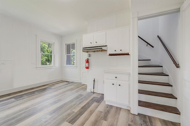 434 Griffing Ave, Riverhead, NY 11901 - kitchen with light wood-style floors, white cabinetry, light countertops, and under cabinet range hood