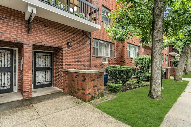 71-14 Sutton Pl Unit 1, Fresh Meadows, NY 11365 - property entrance with brick siding, a yard, and a balcony