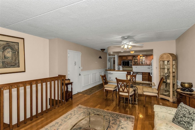 71-14 Sutton Pl Unit 1, Fresh Meadows, NY 11365 - dining room featuring dark wood-style floors, ceiling fan, wainscoting, and a textured ceiling