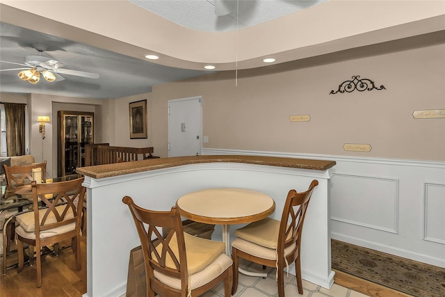 71-14 Sutton Pl Unit 1, Fresh Meadows, NY 11365 - dining area featuring ceiling fan, recessed lighting, a wainscoted wall, and a bar