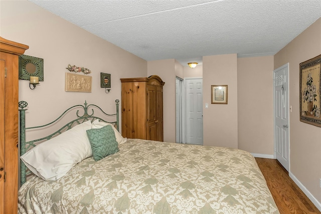 71-14 Sutton Pl Unit 1, Fresh Meadows, NY 11365 - bedroom featuring wood finished floors, a closet, baseboards, and a textured ceiling