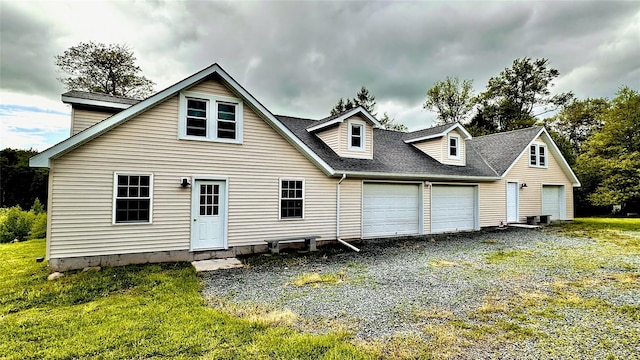 674 Sackett Lake Rd, Monticello, NY 12701 - rear view of house featuring roof with shingles, an attached garage, and a yard