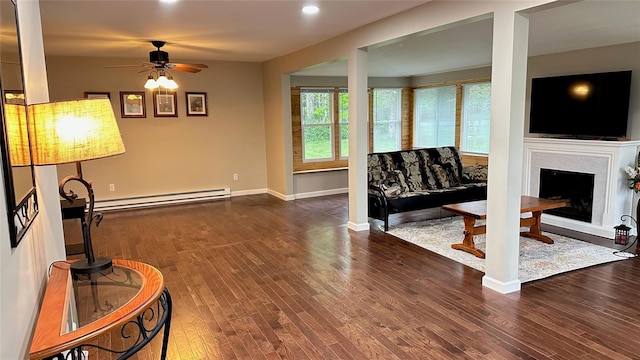 674 Sackett Lake Rd, Monticello, NY 12701 - living room with baseboard heating, ceiling fan, wood finished floors, a fireplace with raised hearth, and recessed lighting