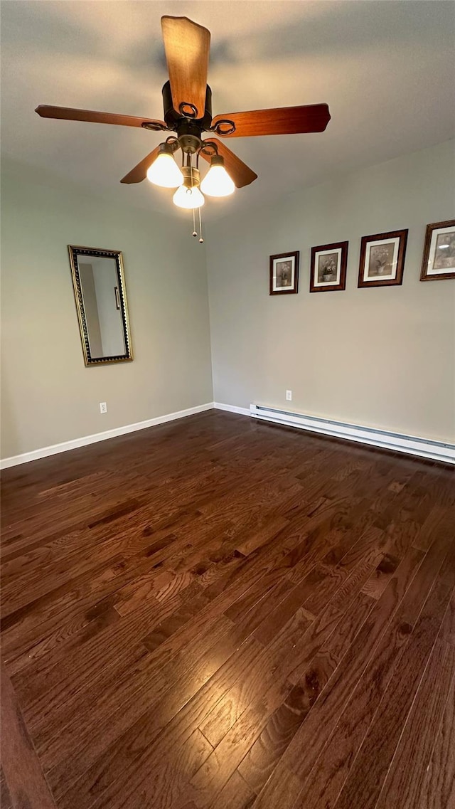 674 Sackett Lake Rd, Monticello, NY 12701 - empty room with dark wood-type flooring, a baseboard heating unit, baseboards, and a ceiling fan