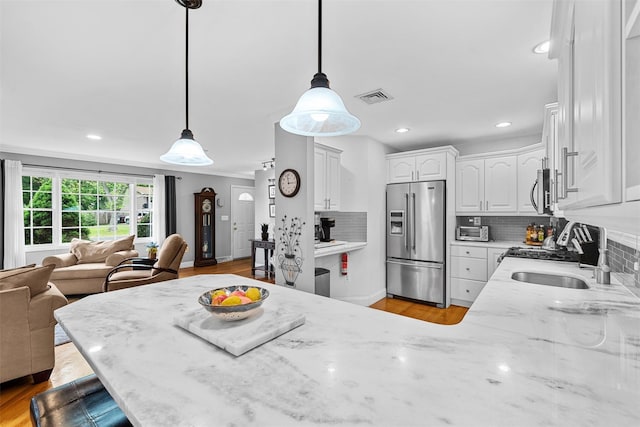 7 Lincoln Dr, Washingtonville, NY 10992 - kitchen with stainless steel fridge with ice dispenser, a peninsula, open floor plan, a sink, and decorative backsplash