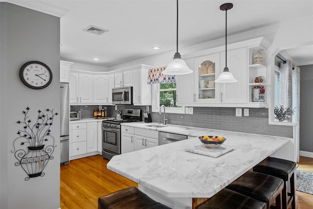 7 Lincoln Dr, Washingtonville, NY 10992 - kitchen featuring stainless steel appliances, a peninsula, a sink, a kitchen breakfast bar, and white cabinets