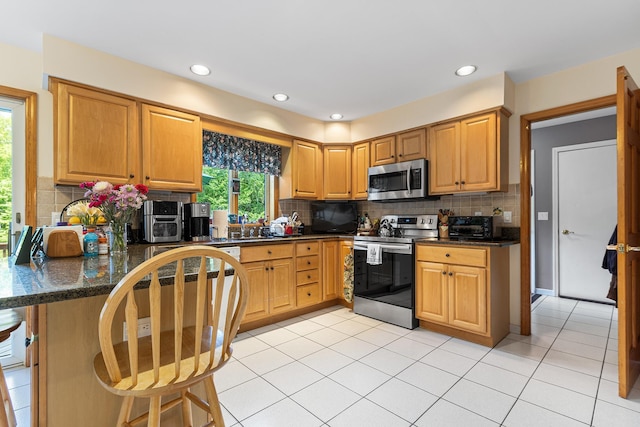 50 Stallion Trl, Brewster, NY 10509 - kitchen featuring appliances with stainless steel finishes, decorative backsplash, a peninsula, light tile patterned floors, and recessed lighting