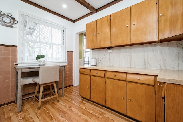 11 Bridge St, Suffern, NY 10901 - kitchen featuring tile walls, light wood-type flooring, light countertops, a wainscoted wall, and brown cabinetry