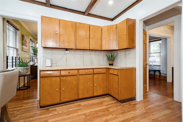 11 Bridge St, Suffern, NY 10901 - kitchen with light countertops, light wood-style floors, backsplash, beamed ceiling, and brown cabinetry
