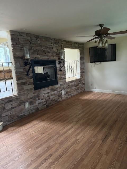 47 Myson St, West Islip, NY 11795 - unfurnished living room with wood finished floors, a ceiling fan, baseboards, and a fireplace