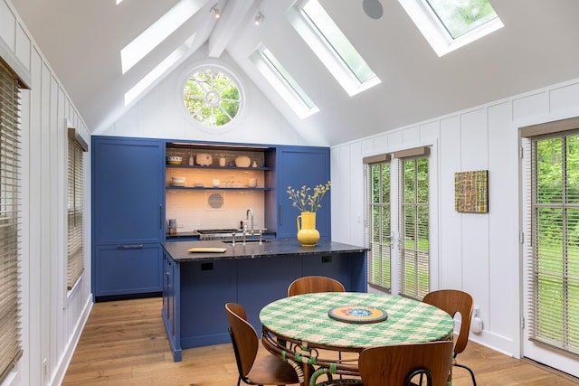 149 Washington Spring Rd, Palisades, NY 10964 - kitchen with blue cabinetry, dark countertops, a decorative wall, light wood finished floors, and a sink