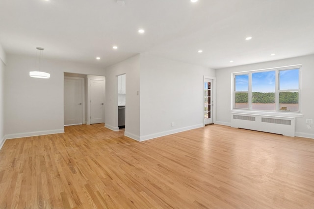 565 Broadway Unit 6B, Hastings-On-Hudson, NY 10706 - unfurnished living room with radiator, baseboards, recessed lighting, and light wood-style flooring