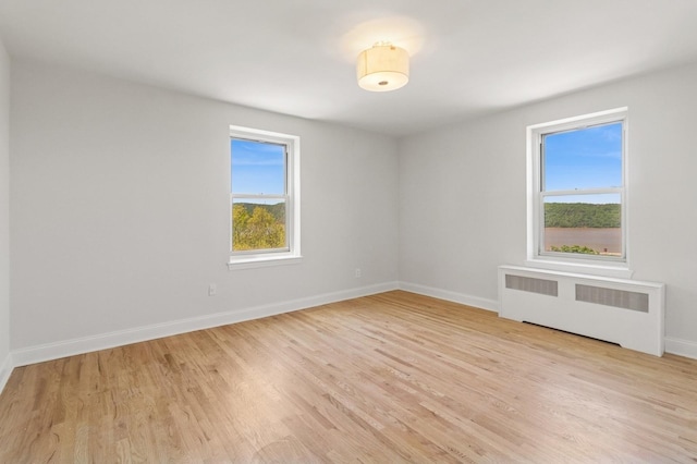565 Broadway Unit 6B, Hastings-On-Hudson, NY 10706 - empty room featuring radiator heating unit, light wood-type flooring, and baseboards