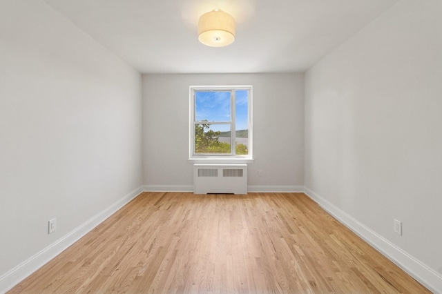 565 Broadway Unit 6B, Hastings-On-Hudson, NY 10706 - spare room featuring radiator heating unit, light wood-style flooring, and baseboards