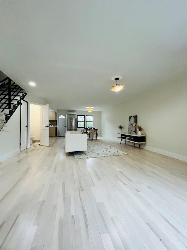 69-14 198th St, Fresh Meadows, NY 11365 - living room featuring light wood-style flooring, baseboards, and stairway