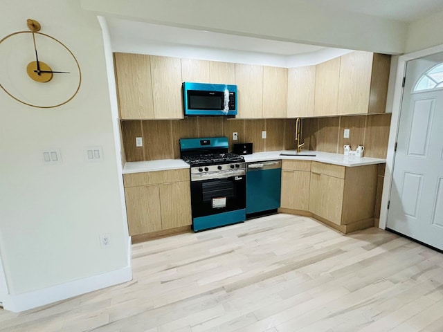 69-14 198th St, Fresh Meadows, NY 11365 - kitchen featuring appliances with stainless steel finishes, light brown cabinets, a sink, light wood-style floors, and light countertops