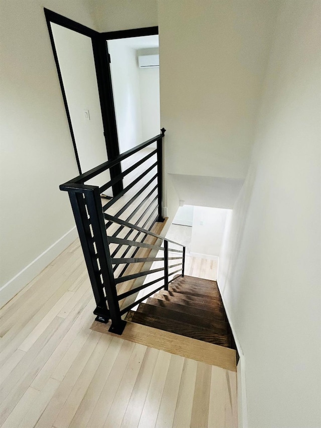69-14 198th St, Fresh Meadows, NY 11365 - staircase featuring wood finished floors, a wall unit AC, and baseboards