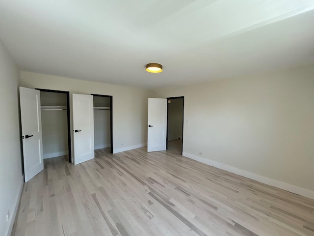 69-14 198th St, Fresh Meadows, NY 11365 - unfurnished bedroom featuring multiple closets, light wood-type flooring, and baseboards
