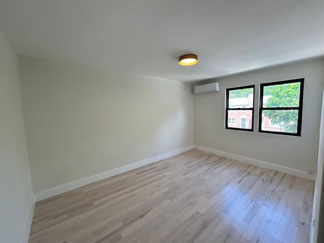 69-14 198th St, Fresh Meadows, NY 11365 - spare room featuring a wall mounted air conditioner, light wood-type flooring, and baseboards