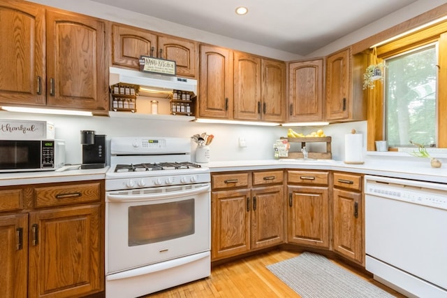 18 Norwood Pl, Nanuet, NY 10954 - kitchen with white appliances, brown cabinets, light wood finished floors, under cabinet range hood, and light countertops