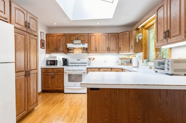 18 Norwood Pl, Nanuet, NY 10954 - kitchen with white appliances, under cabinet range hood, light wood-type flooring, light countertops, and recessed lighting