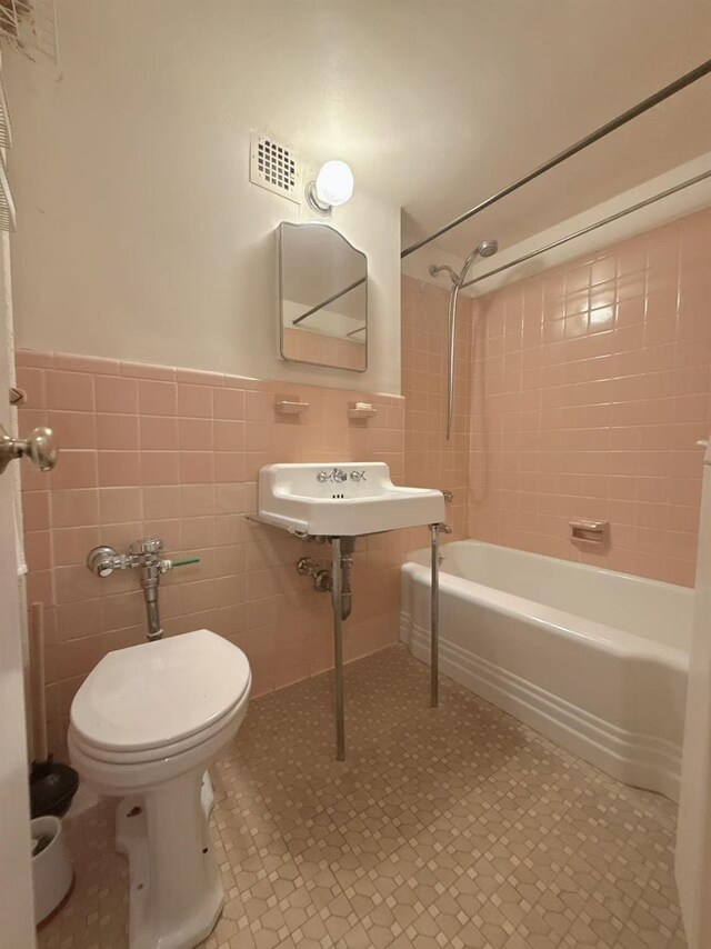 35-11 85th St Unit 6A, Jackson Heights, NY 11756 - bathroom featuring tile walls, shower / washtub combination, toilet, a wainscoted wall, and tile patterned floors