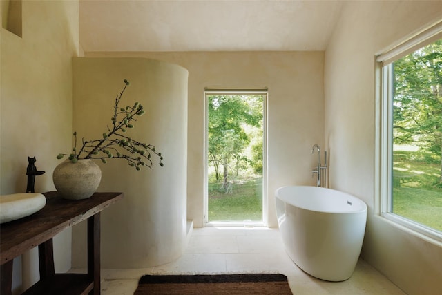 101 Holmes Rd, Newburgh, NY 12550 - full bath featuring a soaking tub, healthy amount of natural light, and tile patterned flooring