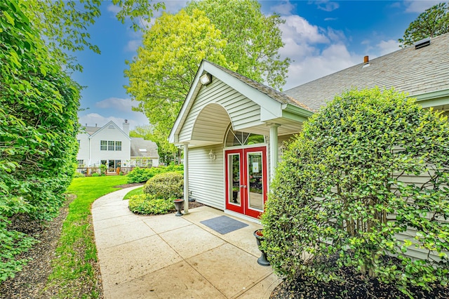 53 Mystic Cir, Bay Shore, NY 11706 - property entrance featuring french doors, a shingled roof, and a lawn