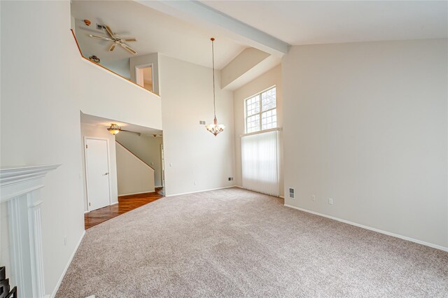 53 Mystic Cir, Bay Shore, NY 11706 - unfurnished living room featuring carpet flooring, a chandelier, high vaulted ceiling, beam ceiling, and baseboards