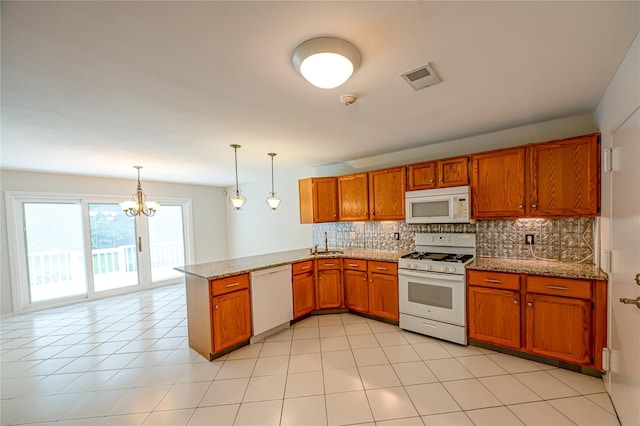 53 Mystic Cir, Bay Shore, NY 11706 - kitchen featuring white appliances, brown cabinetry, a peninsula, decorative backsplash, and a chandelier