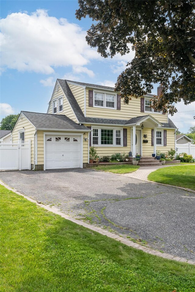 1547 Lincoln Blvd, Bay Shore, NY 11706 - view of front of home featuring asphalt driveway, an attached garage, a shingled roof, and a chimney