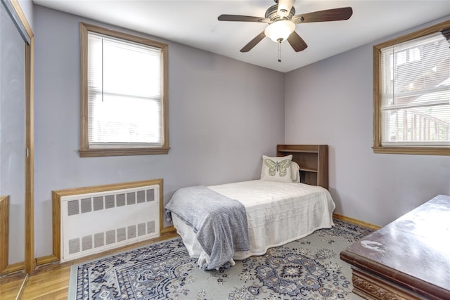 1547 Lincoln Blvd, Bay Shore, NY 11706 - bedroom featuring radiator heating unit, light wood-style floors, baseboards, and ceiling fan
