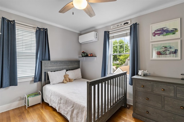 10 Mcbride Ave, White Plains, NY 10603 - bedroom with an AC wall unit, light wood-type flooring, crown molding, a ceiling fan, and baseboards