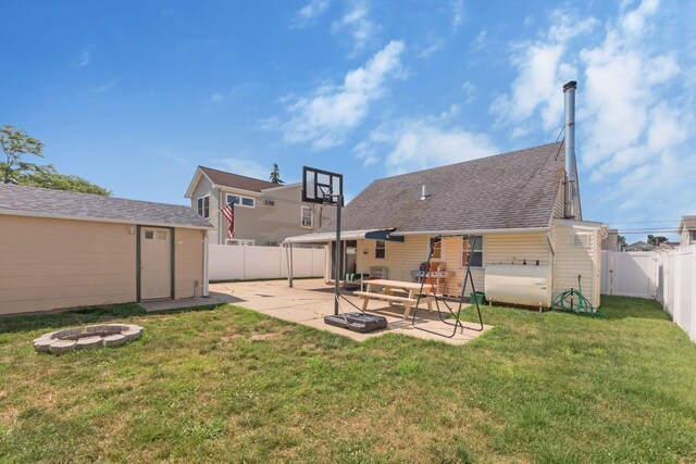 820 Mirabelle Ave, Westbury, NY 11590 - rear view of house featuring an outdoor fire pit, a fenced backyard, a patio area, an outdoor structure, and roof with shingles