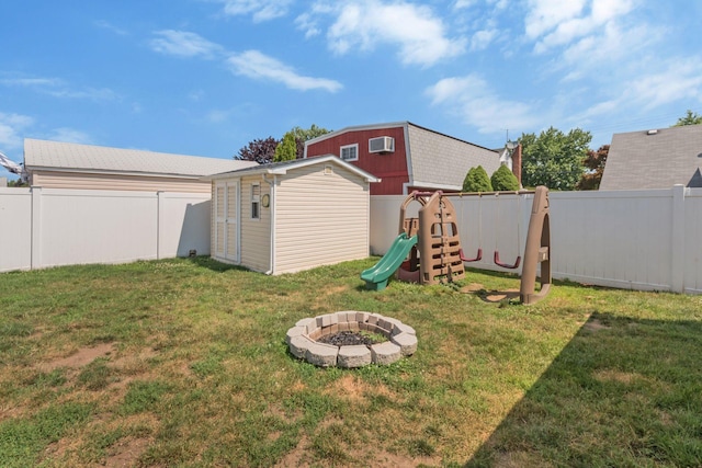 820 Mirabelle Ave, Westbury, NY 11590 - fenced backyard with a storage unit, an outdoor fire pit, a playground, and a wall unit AC