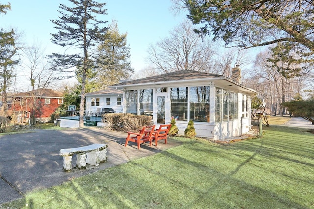 10 Glenbrook Rd, Monsey, NY 10952 - back of property with a chimney, a sunroom, and a yard
