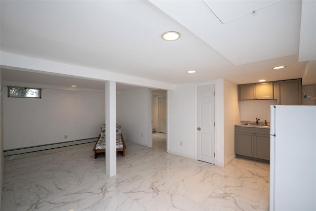6 Willow Dr, Massapequa Park, NY 11762 - finished basement featuring a baseboard heating unit, freestanding refrigerator, recessed lighting, a sink, and light marble finish flooring