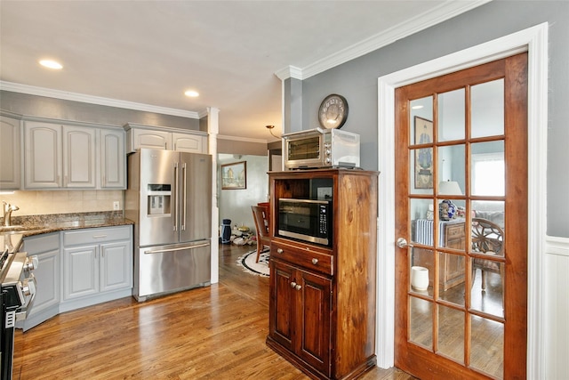 6 Willow Dr, Massapequa Park, NY 11762 - kitchen with stainless steel appliances, crown molding, a sink, light wood-type flooring, and dark stone counters