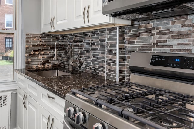 3965 51st St Unit 1C, Woodside, NY 11377 - kitchen with stainless steel range with gas cooktop, a sink, decorative backsplash, white cabinets, and range hood