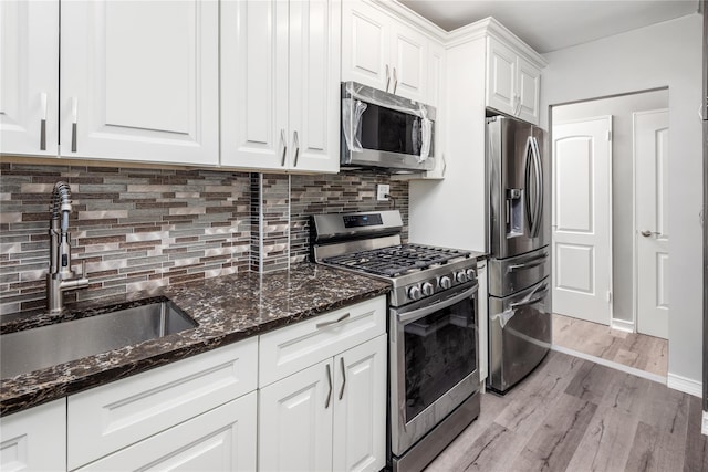 3965 51st St Unit 1C, Woodside, NY 11377 - kitchen featuring stainless steel appliances, a sink, light wood finished floors, white cabinetry, and tasteful backsplash