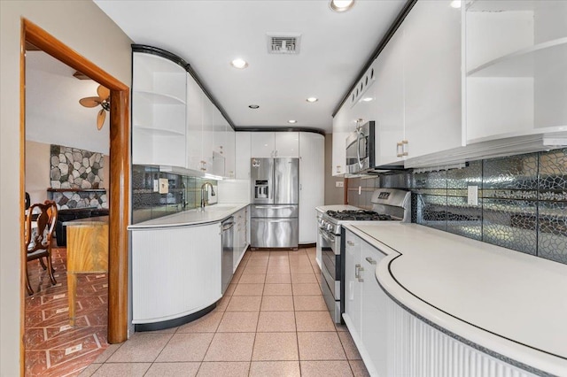 4520 Merrick Rd, Massapequa, NY 11758 - kitchen with appliances with stainless steel finishes, open shelves, white cabinets, backsplash, and light countertops