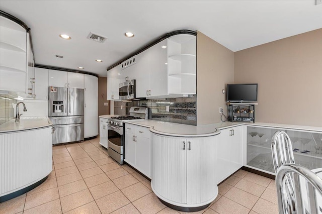 4520 Merrick Rd, Massapequa, NY 11758 - kitchen with open shelves, stainless steel appliances, a sink, white cabinets, and backsplash