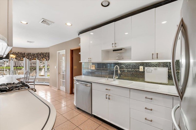 4520 Merrick Rd, Massapequa, NY 11758 - kitchen with appliances with stainless steel finishes, a sink, decorative backsplash, white cabinets, and recessed lighting