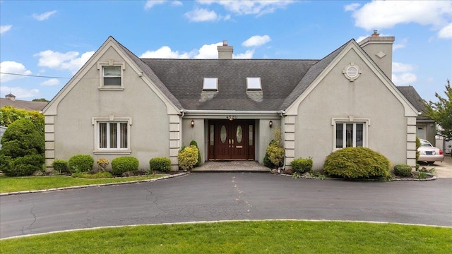 4520 Merrick Rd, Massapequa, NY 11758 - view of front of property with a chimney, stucco siding, and a shingled roof