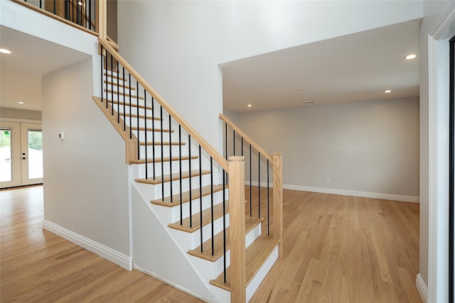 482 S 5th St, Lindenhurst, NY 11757 - stairs with wood finished floors, french doors, baseboards, and recessed lighting