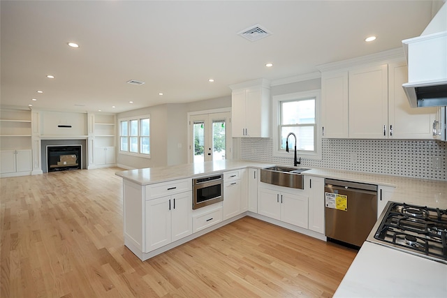 482 S 5th St, Lindenhurst, NY 11757 - kitchen featuring stainless steel appliances, a sink, a peninsula, light wood-type flooring, and recessed lighting