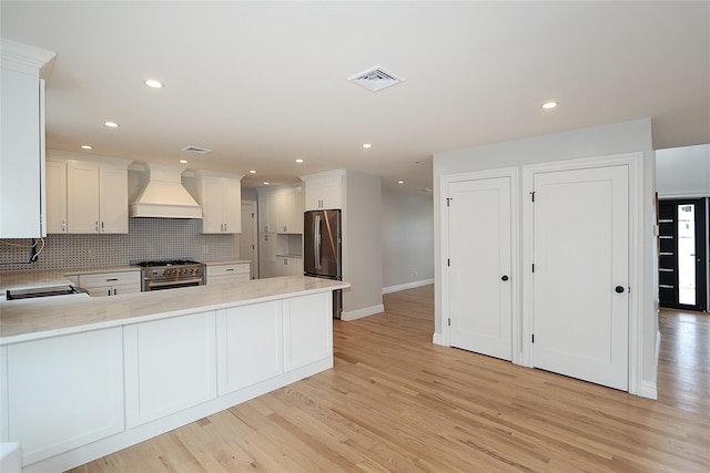 482 S 5th St, Lindenhurst, NY 11757 - kitchen featuring custom range hood, appliances with stainless steel finishes, light wood finished floors, decorative backsplash, and recessed lighting